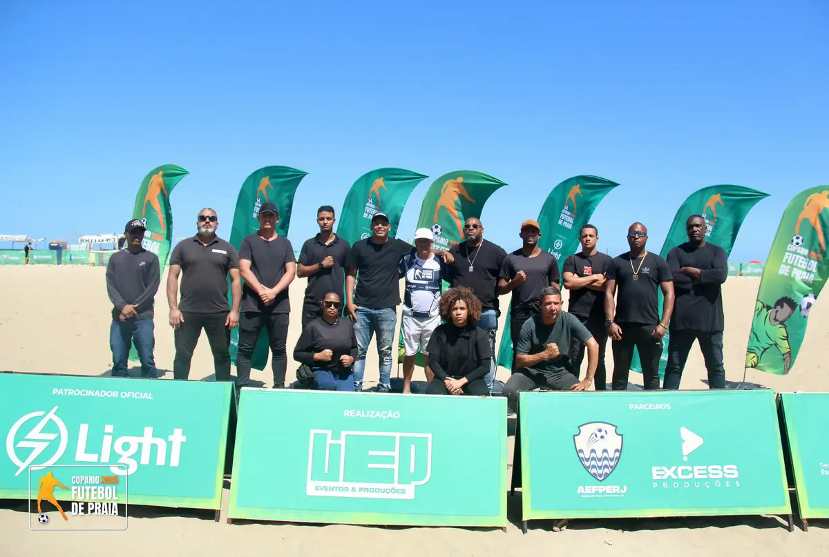 Equipe de segurança posa em frente aos painéis dos patrocinadores
