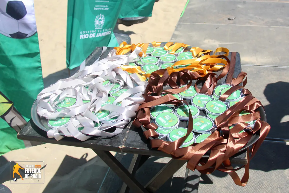 Mesa com medalhas e troféus da premiação